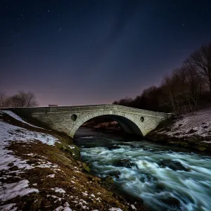 Nighttime Stone Bridge over Rapid River under Starry Sky with Milky Way Visible. Long Exposure Landscape Astrophotography.