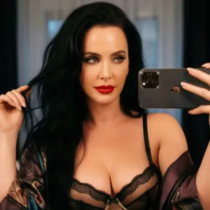 Sultry boudoir photography Katy Perry looking at iPhone.. Silks, elegant lingerie, seductive