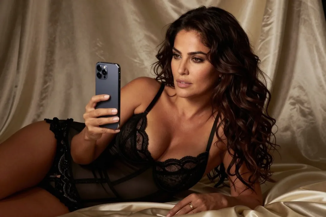Sultry boudoir photography Salma Hayek looking at iPhone.. Silks, elegant lingerie, seductive